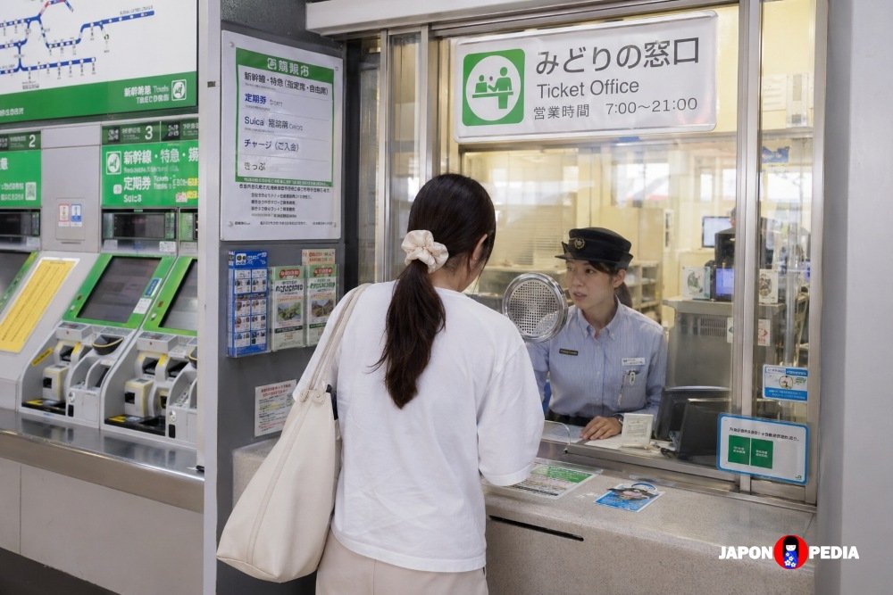 Mujer comprando billetes de tren en una estación de Japón